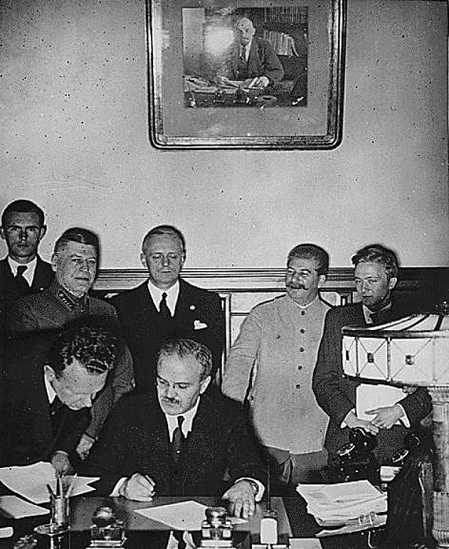 Moskau, 23. August 1939, Außenminister Molotow unterschreibt den deutsch-sowjetischen Nichtangriffspakt, im Hintergrund von Ribbentrop und Stalin, public domain