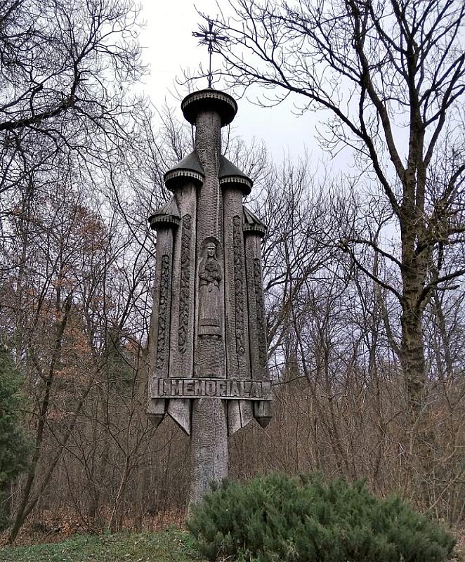 Wald bei Staniūnai (Kaizerlingas), 2018, Eine 1984 aufgestellte Holzskulptur am Eingang des Geländes, Panevėžio apskrities Gabrielės Petkevičaitės-Bitės viešoji Biblioteka, A. Veličkienė