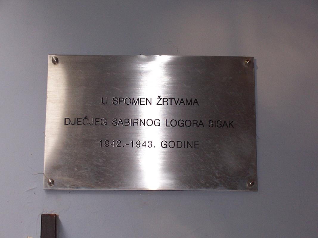 Sissek, 2006, Gedenktafel im ehemaligen Schulgebäude, das zum Lager gehörte, Stiftung Denkmal, Stefan Dietrich