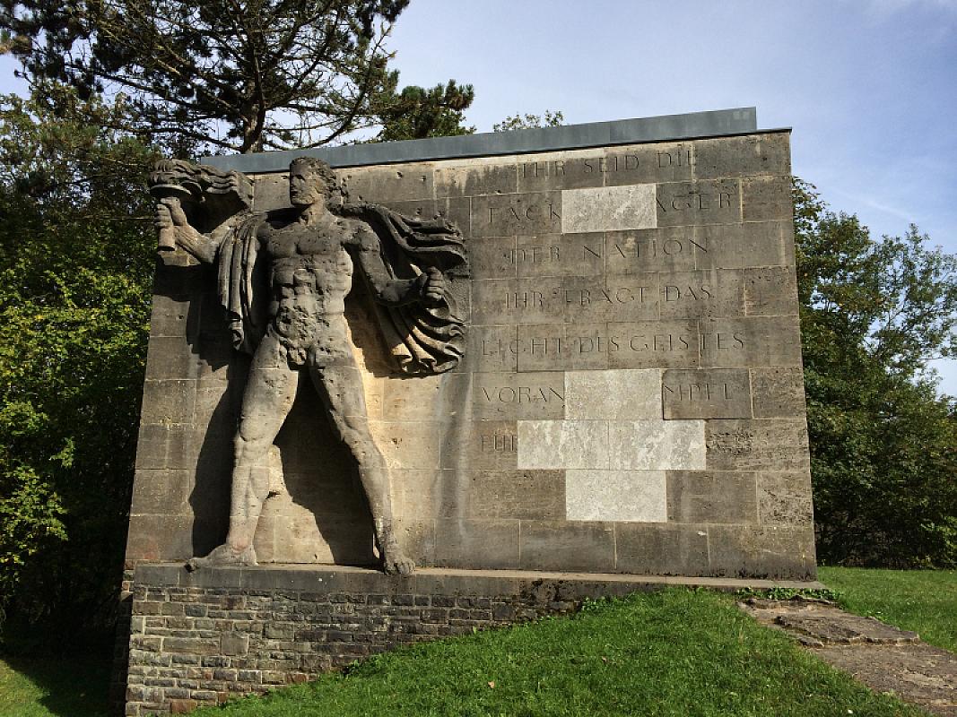 NS-Ordensburg Vogelsang, 2014, Der Fackelträger auf dem »Sonnwendplatz« auf der Burg Vogelsang im heutigen Zustand mit zahlreichen Einschusslöchern, Gemini79 / Wikimedia Commons
