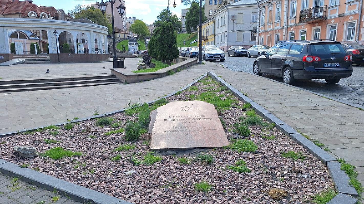 Czernowitz, 2026, Gedenkstein mit dem Hauptplatz des ehemaligen Ghettos im Hintergrund, Stiftung Denkmal